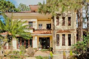 an old house with trees in front of it at HeniSi Homestay Măng Đen Villa in Kon Von Kla