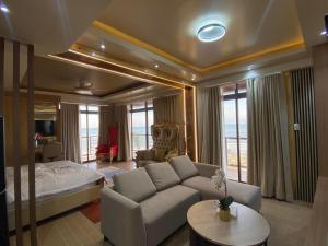 a living room with a couch and a bed at The Baywalk Sunset Resort in Agoo