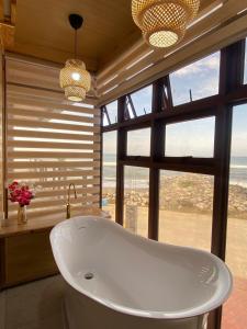 a bath tub in a bathroom with a large window at The Baywalk Sunset Resort in Agoo