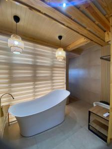 a bath tub in a bathroom with wooden ceilings at The Baywalk Sunset Resort in Agoo +14 photos