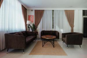 a living room with two couches and a table at Pandan Inn Boutique Hotel in Kota Bharu