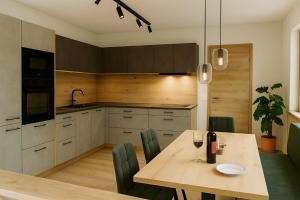 Una cocina con una mesa de madera y sillas verdes. en Hochthron Suites, 