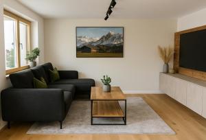 Una sala de estar con un sofá y un televisor. en Hochthron Suites, 