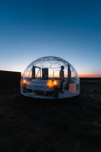 a man standing inside of a glass igloo at Aurora Igloo North in Hvammstangi