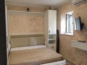 a small bedroom with a bed and a window at Casa Vacanze Sannazzaro Flat in Naples