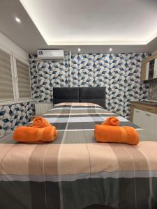 een slaapkamer met een bed met oranje handdoeken erop bij Central Square Apartment in Skopje