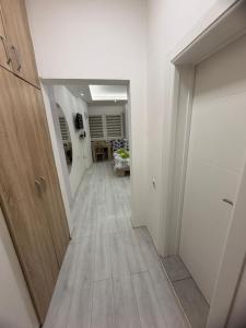 een hal met witte muren en een houten vloer bij Central Square Apartment in Skopje