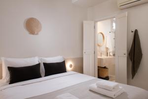 ein Schlafzimmer mit einem Bett, auf dem zwei Handtücher liegen in der Unterkunft Terra Maria Hotel in Mykonos Stadt