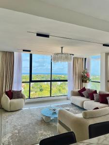 a living room with two couches and a large window at Mira Heights Suites & Conferencing Mombasa in Mombasa