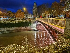 a bridge over a river at night with christmas lights at River Palace Suite in Tríkala