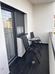 a room with two chairs and a table and a window at Two modern apartments in Sibiu