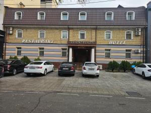 een hotel met auto's voor het hotel bij Arien Plaza in Muruntau