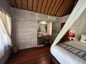 a bedroom with a bed and a desk with a mirror at Pondok Lembongan in Nusa Lembongan