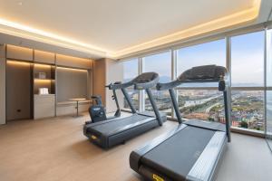 a room with a gym with a treadmill and windows at JI Hotel Hangzhou Xiaoshan Chaoyang Subway Station in Hangzhou