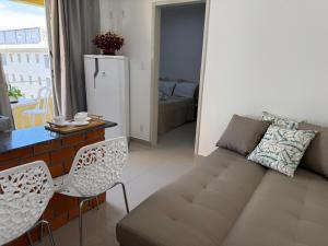 a living room with a couch and a table and chairs at Casa Da Praia Apart Hotel in Florianópolis