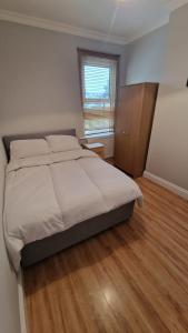 a bedroom with a large bed and a wooden floor at Dartford Haven in Dartford