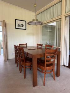 Relax at Tranquil Rye short walk to beach & shops في راي: غرفة طعام مع طاولة وكراسي خشبية +5 صور