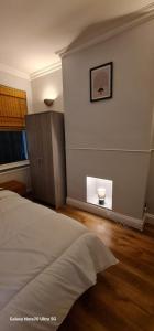 a bedroom with a bed and a wall with a window at Dartford Haven in Dartford