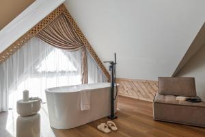 a large bathroom with a tub and a chair at Aparthotel Białka SKI, Odkryj-Bialke in Białka Tatrzańska