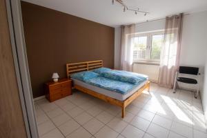 een slaapkamer met een bed, een raam en een stoel bij Ferienwohnung Josi in Ebermannstadt