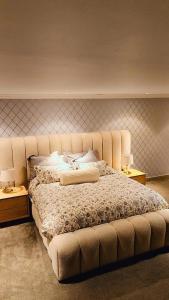 een groot bed in een kamer met twee tafels bij Seaside Luxe Blouberg Mansion in Cape Town +16 foto's