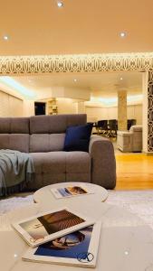 een woonkamer met een bank en een tafel bij Seaside Luxe Blouberg Mansion in Cape Town