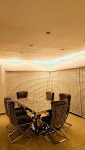 een eettafel en stoelen in een kamer bij Seaside Luxe Blouberg Mansion in Cape Town