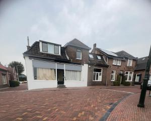 a house on a street with a brick driveway at Sfeervolle kamer aan de Dorpsdijk met Gratis Ontbijt in Lobith