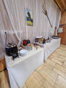 Glamp Pr Kuzuc في سيركلجي نا جورينجسكيم: طاولتين بيض وعليهم طعام في غرفة