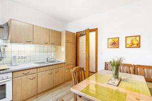 Ferienwohnung Am Kirchplatz في باد وونينبرج: مطبخ بدولاب خشبي وطاولة خشبية