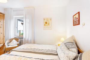 Ferienwohnung Am Kirchplatz في باد وونينبرج: غرفة نوم بها سرير وكرسي ونافذة