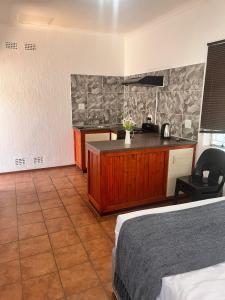 Royal King Guest House Roodepoort في روديبورت: غرفة نوم بسرير ومطبخ مع كونتر +88 صورة
