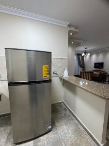 a stainless steel refrigerator in a kitchen with a counter at Privado Modern Apartment Garden View B11 Group114 2BR in Madinaty