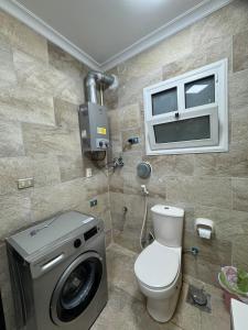 a bathroom with a toilet and a washing machine at Privado Modern Apartment Garden View B11 Group114 2BR in Madinaty +14 photos
