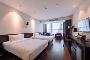 Postel nebo postele na pokoji v ubytování Orange Hotel Hangzhou Jiubao Passenger Transport Center