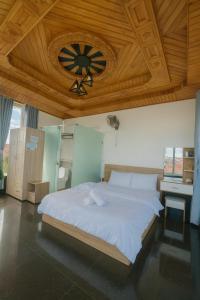 ein Schlafzimmer mit einem großen Bett und einer Holzdecke in der Unterkunft Sunrise Guest House in Da Thanh