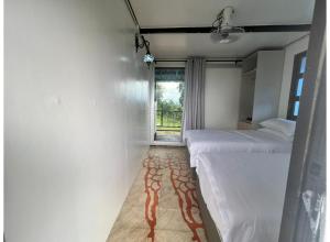 a white room with two beds and a window at OYO 91261 Thebukit, Langkawi in Kuah