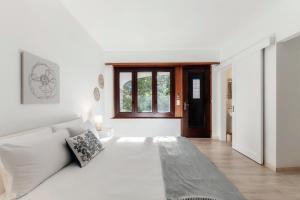 un salon blanc avec un canapé blanc et une fenêtre dans l'établissement Florida Ascona Rooms by Quokka 360 - Close to Lake and City, à Ascona