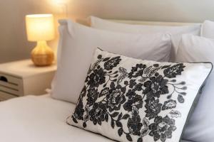 a black and white pillow on a bed with a lamp at Florida Ascona Rooms by Quokka 360 - Close to Lake and City in Ascona