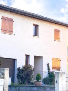 ein weißes Haus mit Holztüren und einem Zaun in der Unterkunft CAL QuEROL UR casa amb xemeneia i billar in Ur