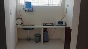 a kitchen with a counter with a microwave on a table at AAFIYA LAKEVIEW APARTMENTS in Coimbatore