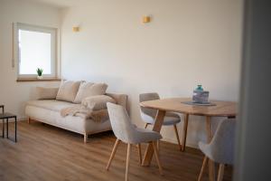 Best Stay Rhöner Gemütlichkeit Dietershausen في كنوزيل: غرفة معيشة بها أريكة وطاولة