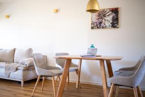 Best Stay Rhöner Gemütlichkeit Dietershausen في كنوزيل: طاولة وكراسي في غرفة معيشة مع أريكة