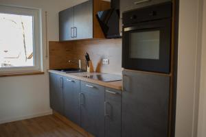 Best Stay Rhöner Gemütlichkeit Dietershausen في كنوزيل: مطبخ مع حوض وميكروويف +5 صور