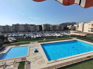 a large swimming pool in a building with a parking lot at Marco Polo 3 pers pool in Mandelieu-La Napoule