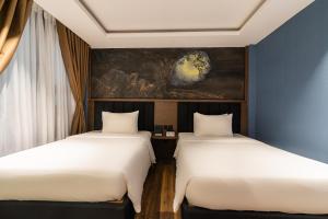 two beds sitting next to each other in a room at Nicecy Hotel Suites & Spa in Ho Chi Minh City