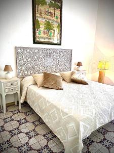 een slaapkamer met een wit bed met een schilderij aan de muur bij Villa Anna in Quartu Sant'Elena