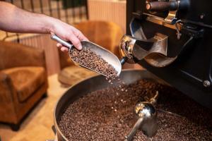 Una persona está vertiendo café en una sartén con una cuchara. en Un grain d'folie, en Villié-Morgon