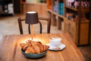 un plato de cruasanes y una taza de café sobre una mesa en Un grain d'folie, en Villié-Morgon