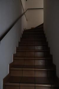 una escalera con escaleras marrones y una pared blanca en Nottetempo, en Desio 2 fotos más